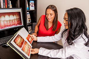 Dr. Johnson shows a patient before and afters of cosmetic dental treatments.