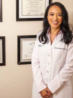 Dr. Charmaine Johnson standing next to her credentials and degrees.